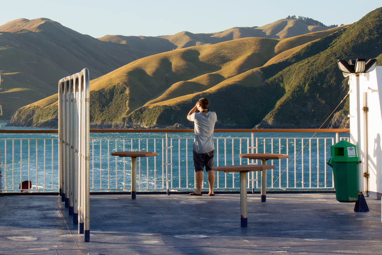 Interislander Aratere Man taking photo of Hills of East Head as ship leaves Tory Channel RH1500